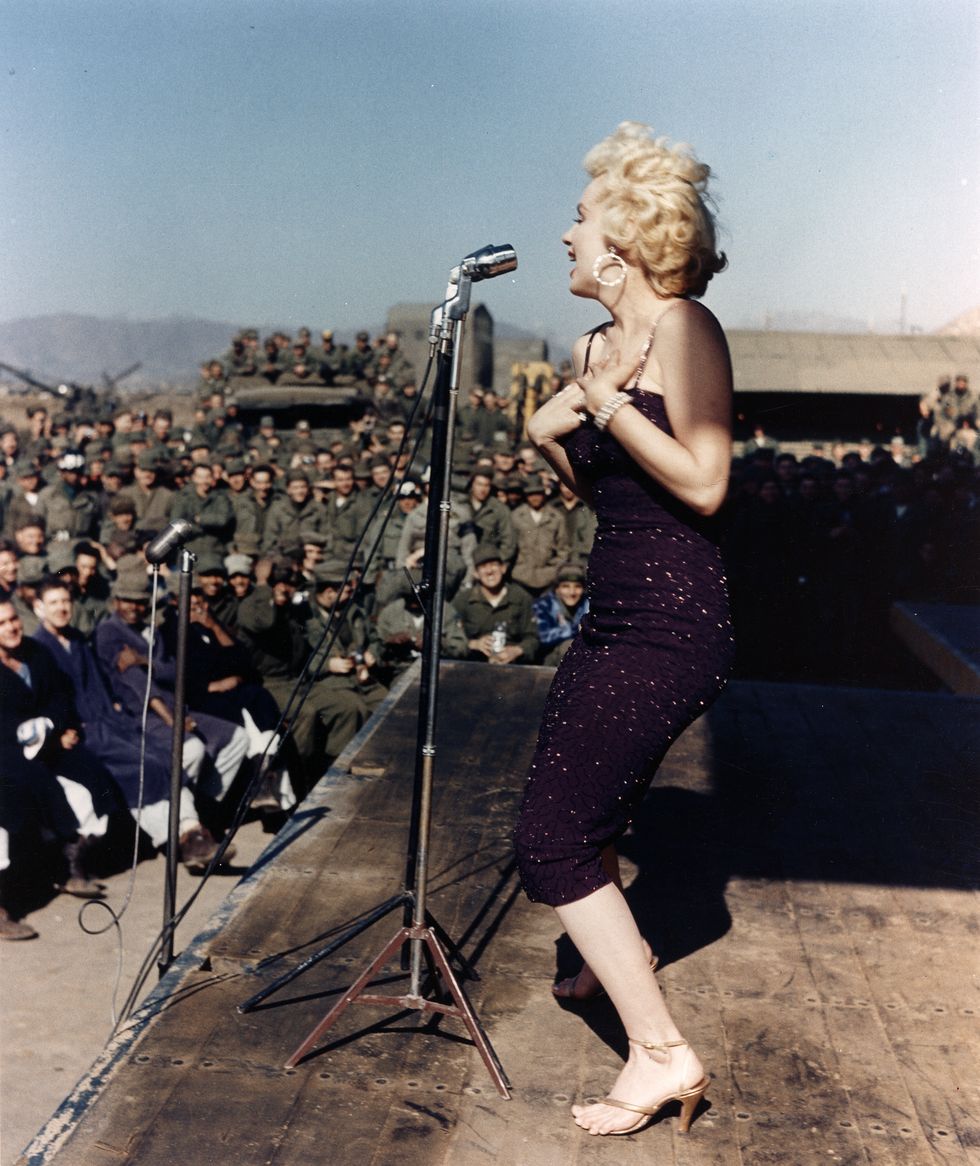 Galerie foto Marilyn Monroe: Marilyn cantand pentru militari americani in Coreea in februarie 1954. Ea si DiMaggio tocmai sosisera in Japonia in luna de miere cand i s-a cerut sa cante pentru trupe, ceea ce a facut, spre disperarea noului ei mire .  (Fotografie de Michael Ochs Archives/Getty Images)